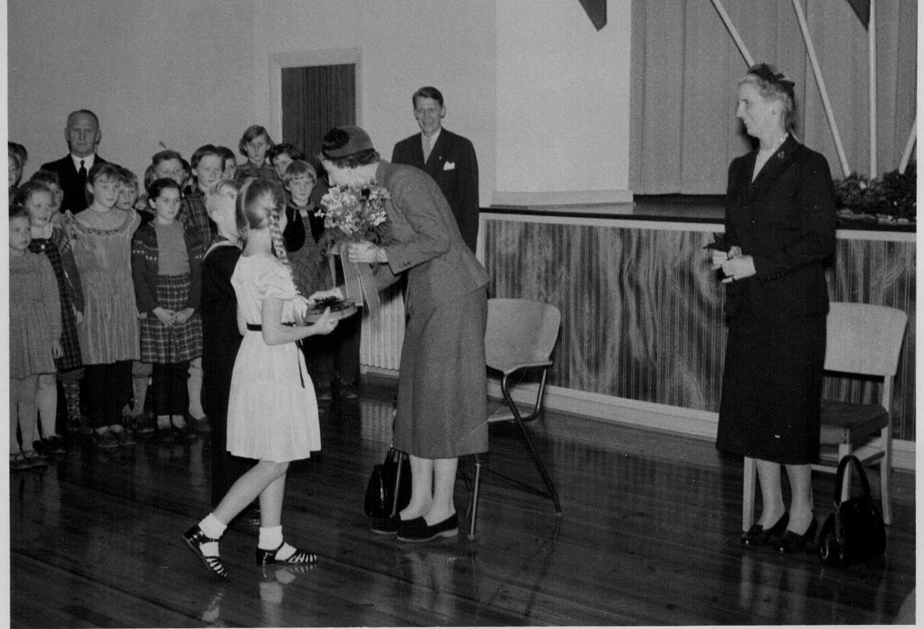 65 Dronning !ngrid i Hovslund skole. Elisabeth Midtgård og Paul Erik Tiedemann overrækker blomster.